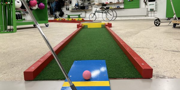 Bild från Fritidsbanken Motala där man ser en minigolfbana med klubba och boll i förgrunden